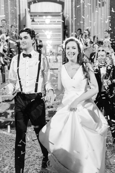Bride and groom exiting reception with confetti