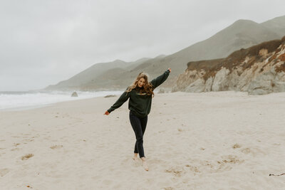 Hannah posing and smiling on the Coast of California