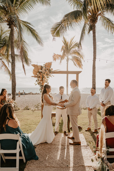 a beach wedding ceremony surrounded by coconut trees planned by sunberry travel co