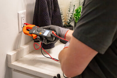 Dove Electric electrician in Albuquerque testing outlet in bathroom