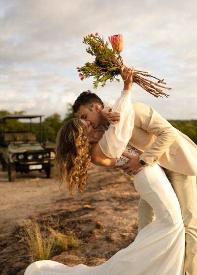 couple celebrates on an outlook in kruger national park after south african safari elopement with danielle boulger photography