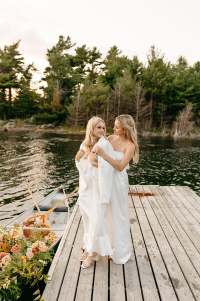 Two women on a dock looking lovingly at each other.