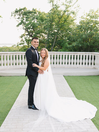 Timeless portrait of a bride and groom looking at the camera at The Hillside Estate in Dallas, TX. Captured by Jolie Smith Photography, specializing in elegant and heartfelt wedding moments.