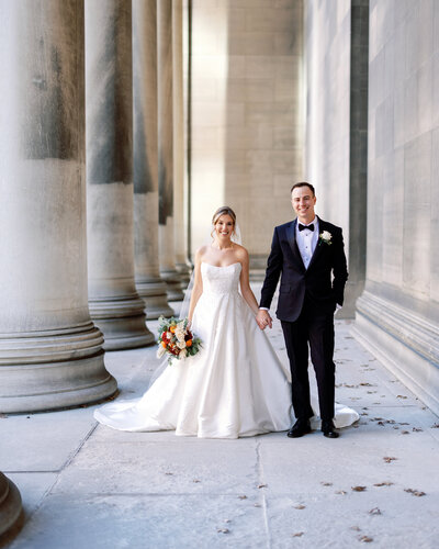 Bride and groom share a quiet, joyful moment standing on the grand stone steps of a Pittsburgh wedding venue.