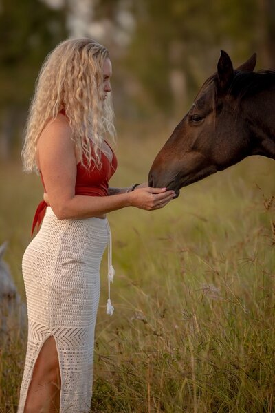Horse retreat moment – woman connects with a horse during somatic experiencing coaching in Australia.