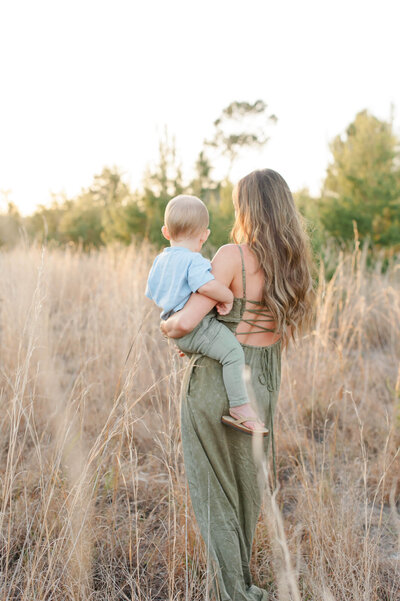 Mom and son walking through a field during their family photo session