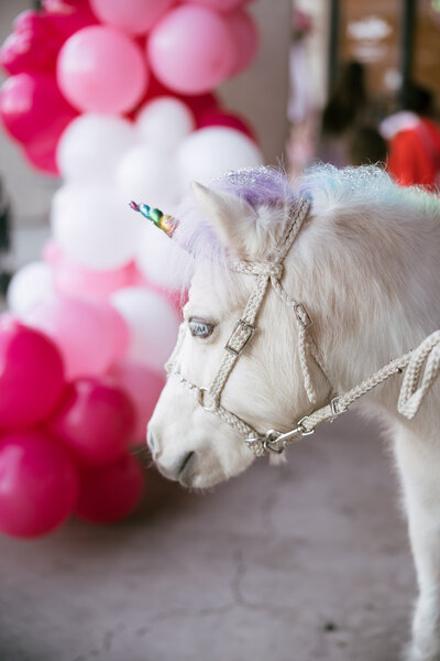 Woman in a movement class kissing her baby laying on her yoga mat