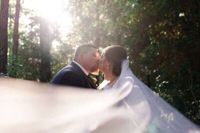 bride and groom kiss on their wedding day at Magnolia Bells in Houston by Swish and Click Photography