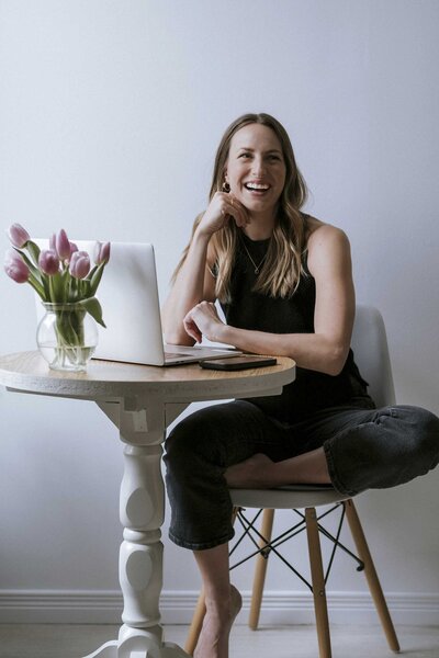 Yoga and Pilates instructor working at a laptop, embodying mindfulness and calm in her approach to wellness. Combining self-love, journaling, and grounding techniques for mental health and self-discovery.