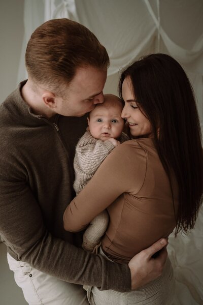 Gezin tijdens newbornshoot in daglicht studio
