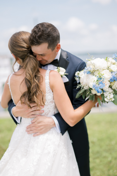 Groom hugging his bride on the lawn at CBMM