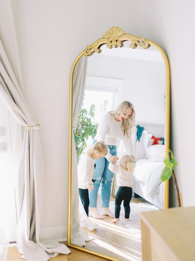 mirror reflection of mom dancing with her two little girls