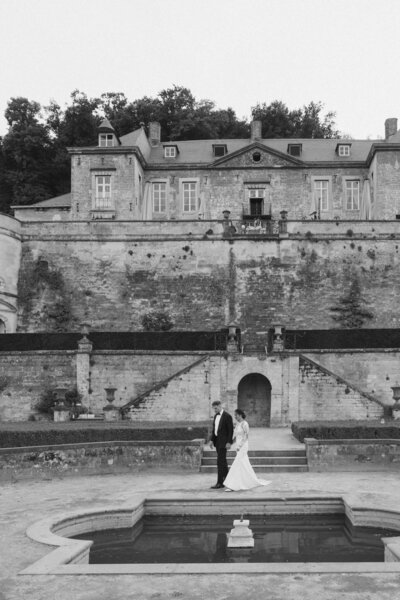 Een bruid en bruidegom lopen weg van het altaar waar ze net getrouwd zijn. De gasten maken twee rijen en blazen bellenblaas naar het bruidspaar toe. Lachende gezichten worden  vastgelegd door Sharon Kastelijns Photography.