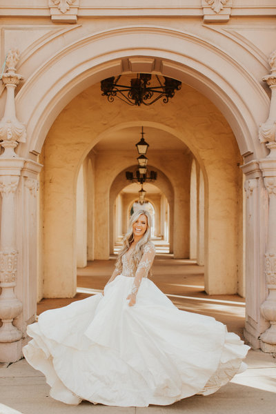 Bride spinning in her dress in a long hallway