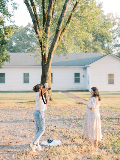 Little Rock photographer Bailey Feeler takes a photo of pregnant woman next to white building