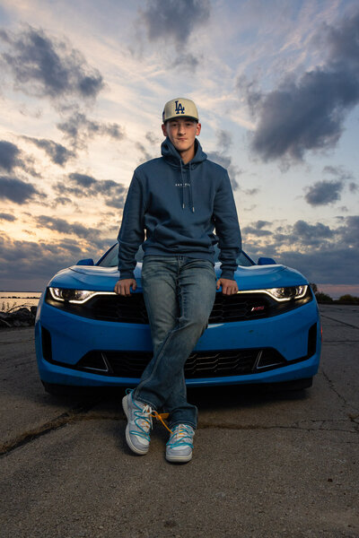 Senior photo session of Brody standing leaning up against his car at a lake in Lawrence KS | Senior Photographer in Lawrence KS