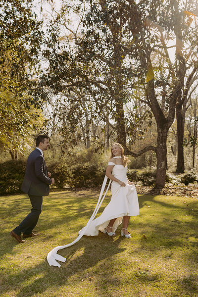 Bride and groom holding their hand while walking together at sunset on the evening of their wedding 