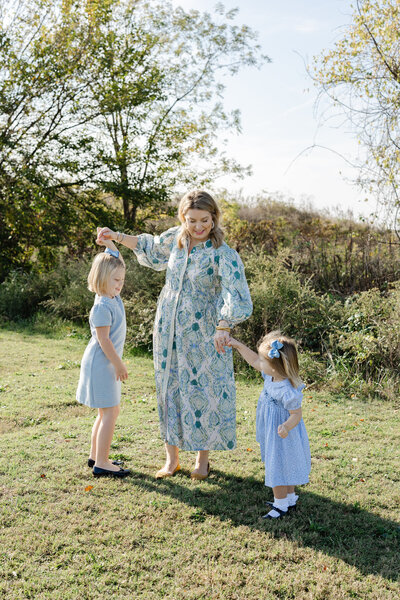 mom and her two daughters twirling at Sculpture Fields