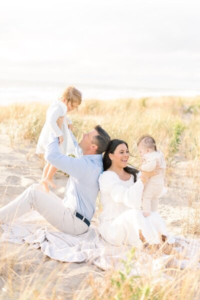A family for 4  laughs together on the beach during their NJ Portrait photos.
