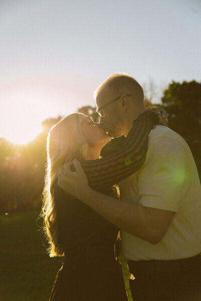 a bridal party look around at eachother and laugh while walking away from a rustic barn