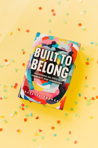 Built to Belong book on a yellow background with confetti. Cover design by Jen Pace Duran of Pace Creative Design Studio