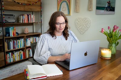 woman wearing glasses working on a laptop computer