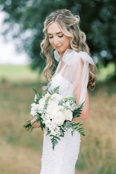 a bride holding a white flower bouquet