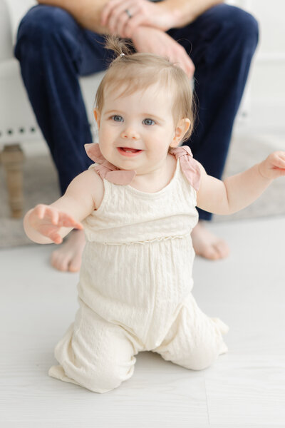12 month old baby girl smiles for milestone portrait