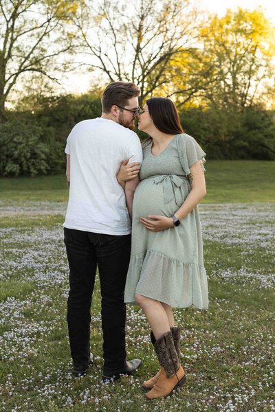 woman holding pregnant belly with husband