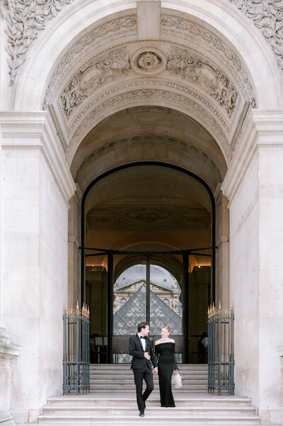 couple walking the steps of the Louvre Paris