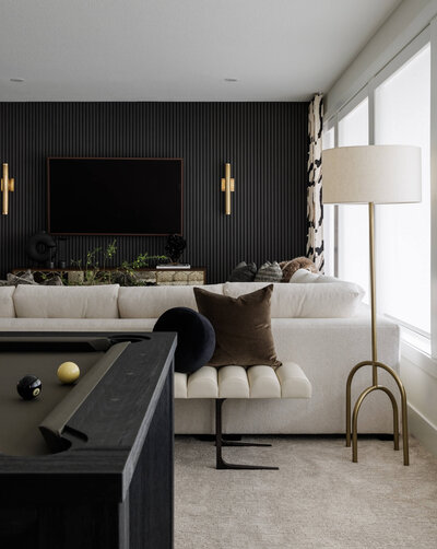 A basement rec room equipped with a custom pool table and a black wood panelling wall detail. 