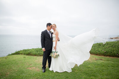 Bride and Groom sitting on chair at their wedding at La Jolla Women's club
