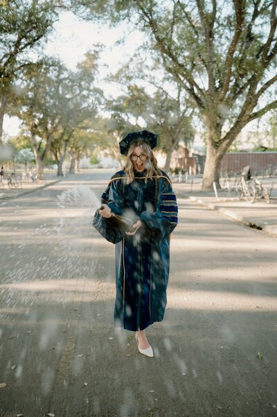 Graduation photo at UC Davis with student spraying champagne in celebration
