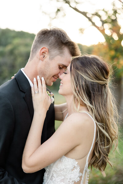 Bride and groom outside at sunset cuddled up