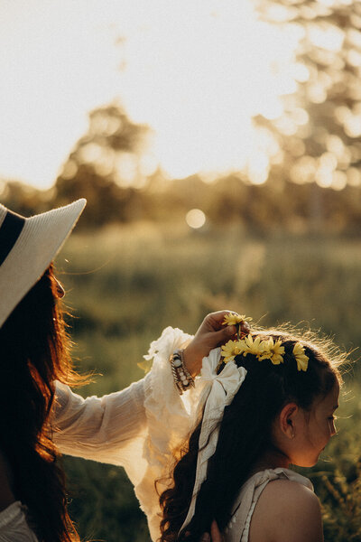 sunshine coast family photographer mum doing daughter's hair at sunset