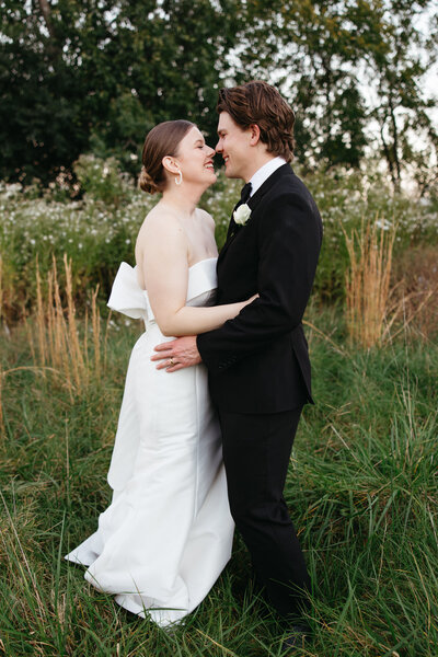 Osage House wedding couple standing in grass outdoors in Cave Springs, Arkansas.