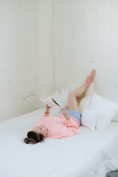 Holistic wellness coach Vanessa reading about menopause while resting—embracing slow living, hormone balance, and midlife healing