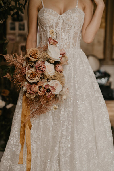 Vintage and luxurious wedding, bridal portrait portraying her luxurious wedding gown and vintage romantic flower bouquet.