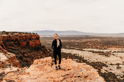 woman standing on red rocks