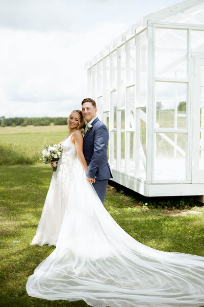 Husband and wife standing in front of a raised barn in MN