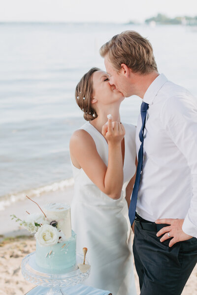 bride and groom in MN kiss on the beach