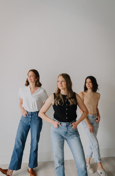 Megan Evans and two of her team members standing in front of a wall