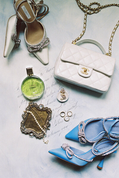 Flatlay featuring classic bridal details white Chanel bag and perfume along with bridal jewelry, rings and Sam Edelman shoes.
