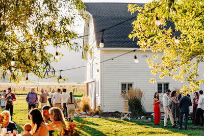 Outdoor wedding reception by white barn at McVey Homestead in Victor, MT