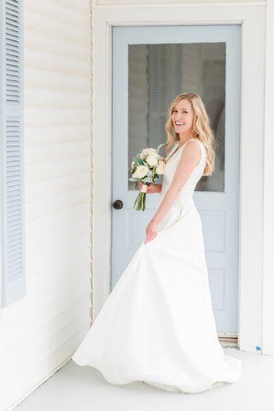 a bride posing on the side porch of a photography studio