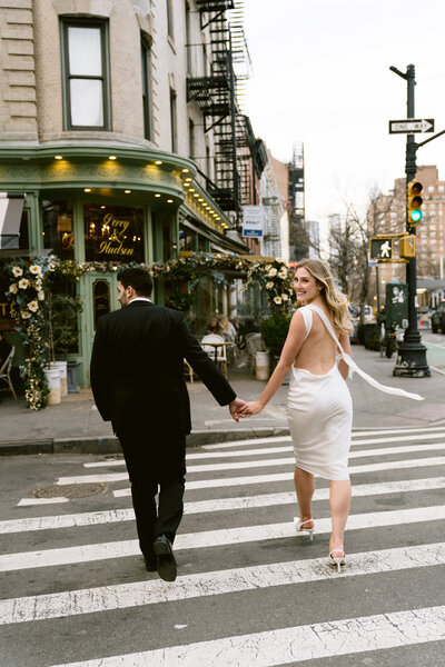 couple holding hands while the bride-to-be smiles over her shoulder