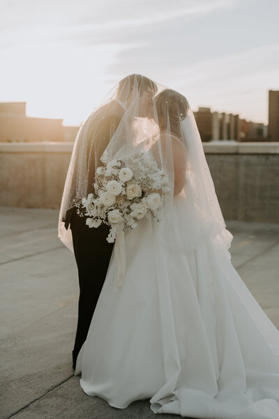 Bride and Groom under veil on rooftop photographed by Wichita Wedding Photographers, The Cantrells