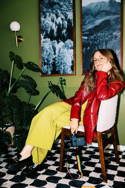 woman sits with arms crossed over knees