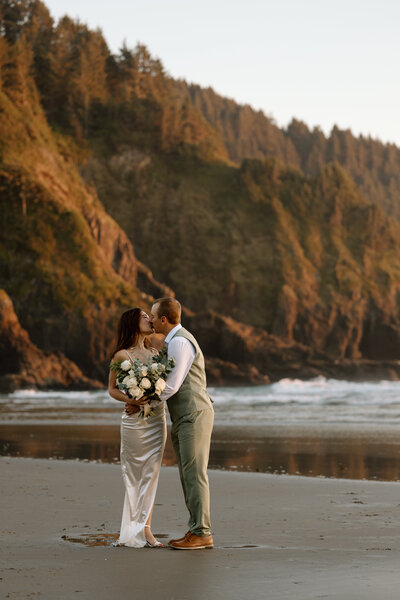 Bride holding up a bouquet of flowers during a beach elopement in Michigan.