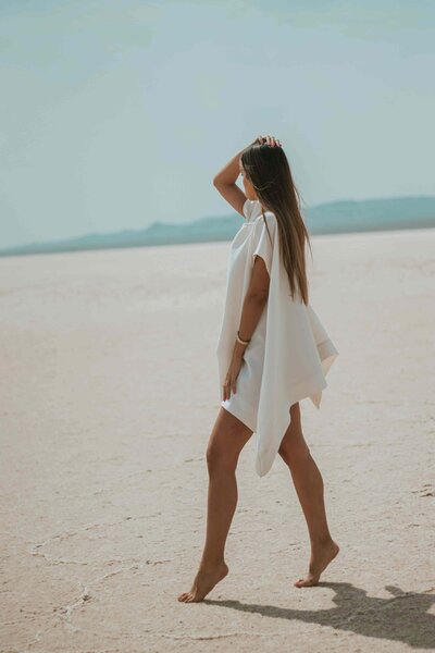 Femme marchant pieds nus dans un paysage ouvert, symbole de légèreté, d’ancrage et de liberté corporelle — une invitation à explorer la reconnexion à soi et au corps via les partages de Brigitte-ostéopathe sur Facebook.
